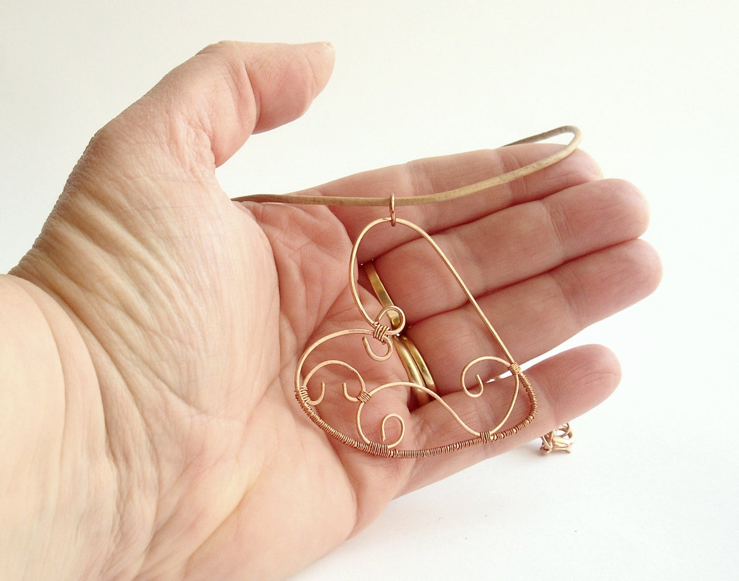 Copper wire wrapped heart pendant with natural leather string.