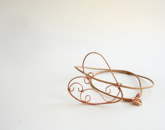 Copper wire wrapped heart pendant with natural leather string.