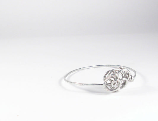 Aluminum wire bracelet with stylized flower. Silver color bangle.